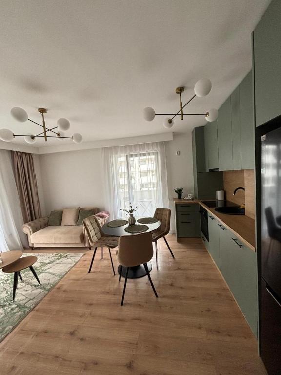 a kitchen and a living room with a table and chairs at Apartament Eroilor Residence in Floreşti