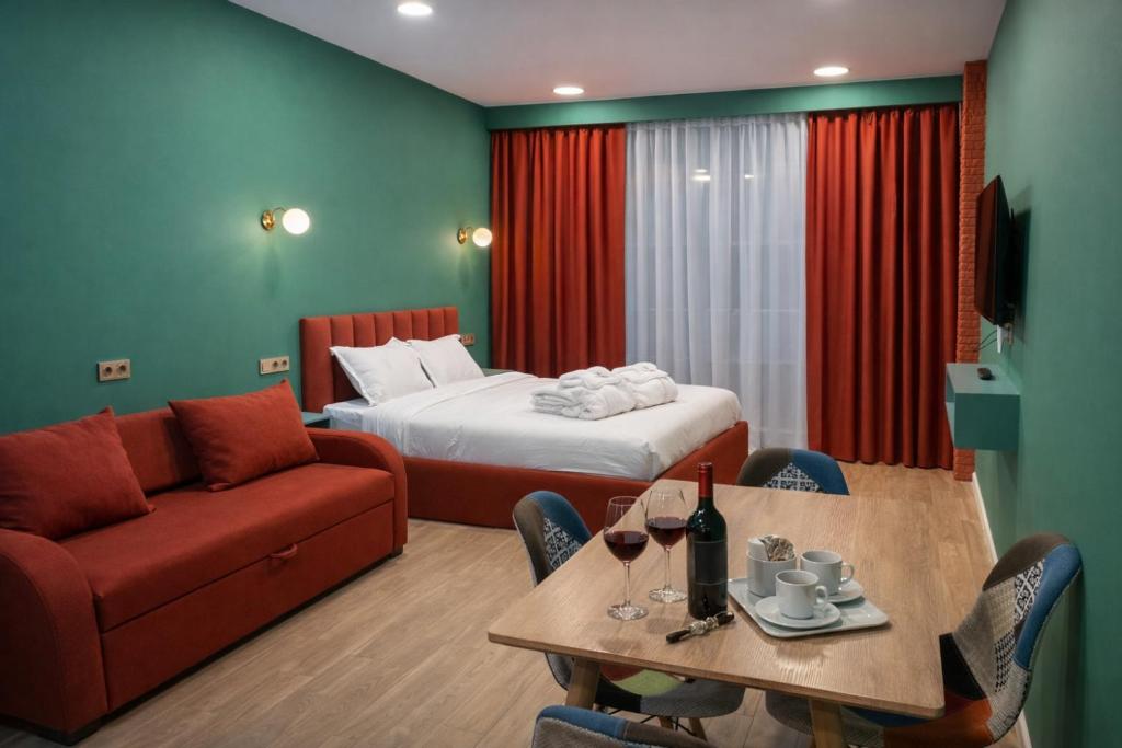 a hotel room with a bed and a table and a couch at Premium New Gudauri Apartments with Balcony & Gondola Views in Gudauri