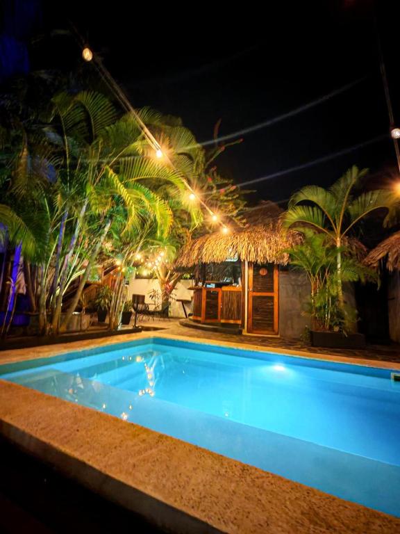 a blue swimming pool at night with a hut at Casa Juntos by Villa Eden in Palomino