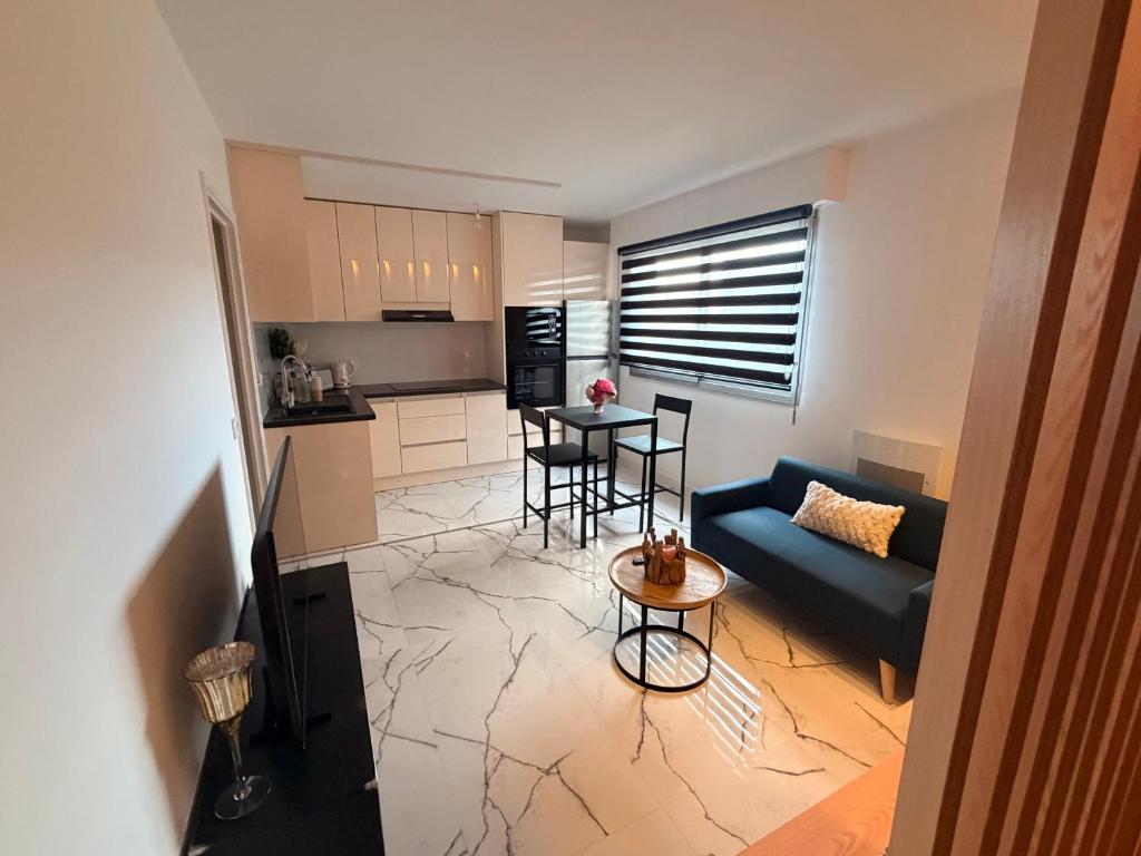 a living room with a couch and a table at Studio neuf élégant- calme & cosy in Oyonnax