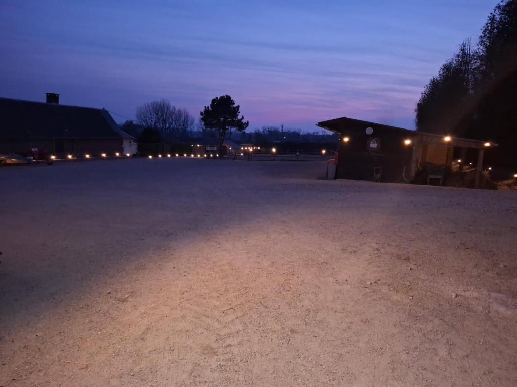 an empty parking lot at night with a building at La jonquiere etablisement climatisé in Landouzy-la-Cour