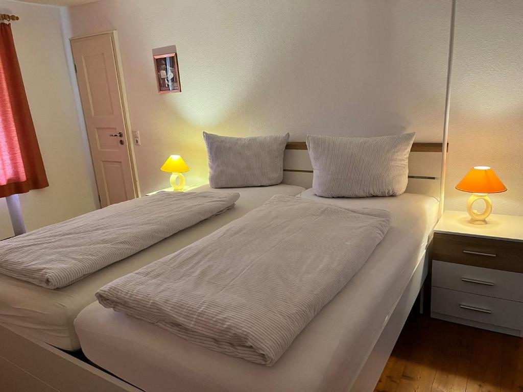 two beds in a room with two lamps on a desk at Gasthaus Adler Weilheim, Waldshut in Weilheim