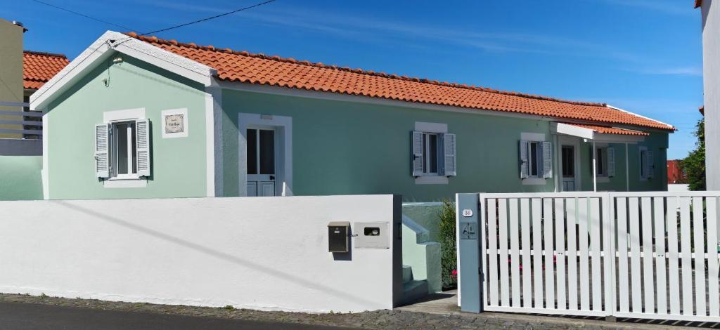 a small blue house with a white fence at Casa da Avó Biza in São Roque do Pico
