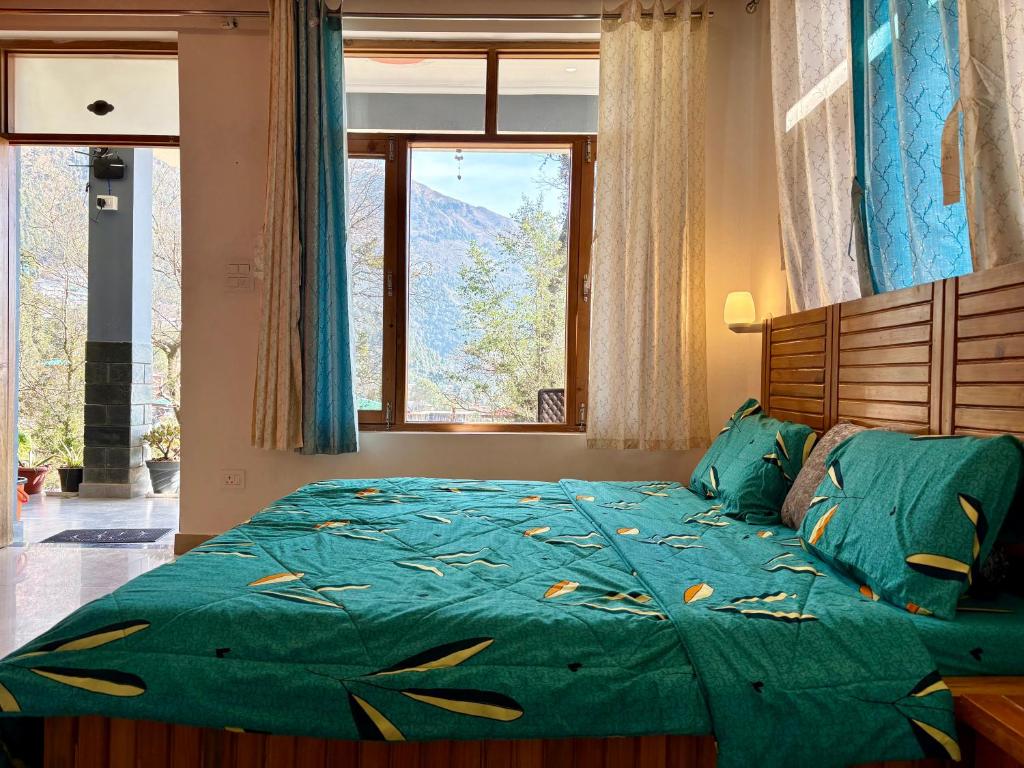 a bedroom with a bed with a green comforter and a window at Brekora X RajStays in McLeod Ganj