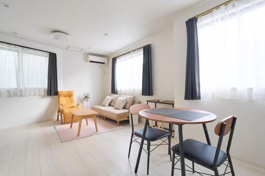 a living room with a table and chairs and a couch at 東京Dong house in Wada