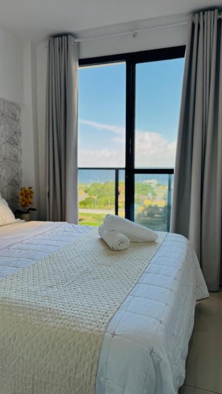 a bedroom with a bed with a large window at Seu refúgio com vista para o mar in Vila Velha