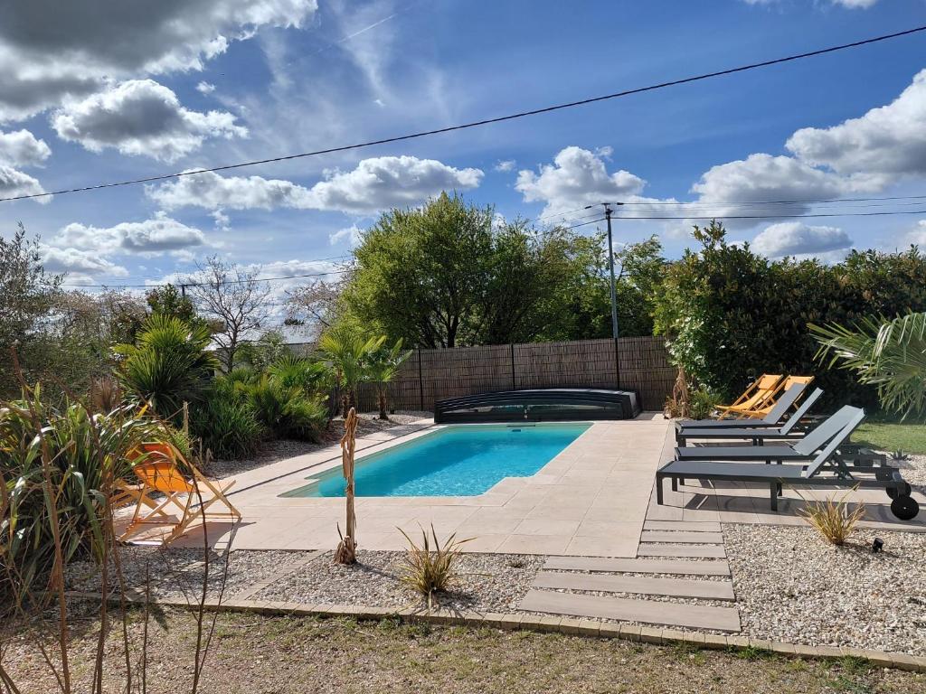a swimming pool in a yard with two lounge chairs at Gites au fil des châteaux de la Loire in Saint-Georges-sur-Cher