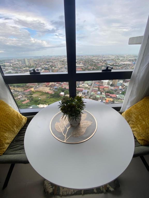 a white table with a plant on it in front of a window at Jbs place at Jtower Residences in Mandaue City