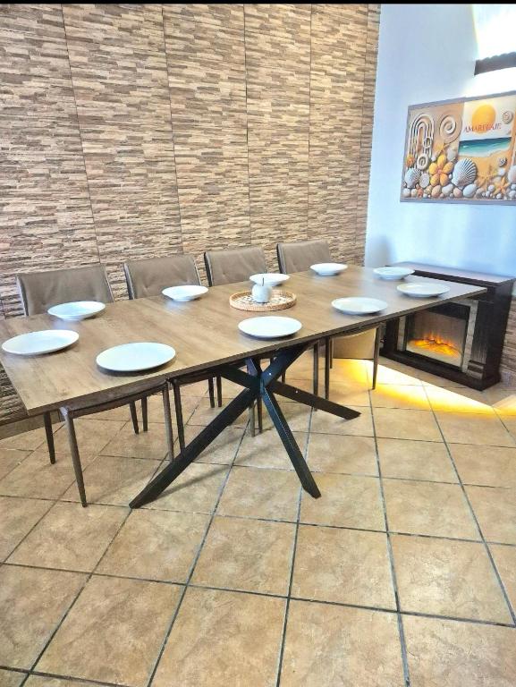 a wooden table in a room with chairs and a fireplace at Amarelaje in Serra de El-Rei