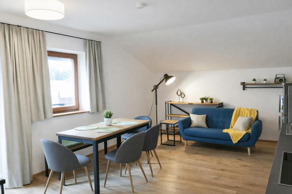 a living room with a blue couch and a table at Quartier No 7 Salzburg Süd Apartments in Grödig