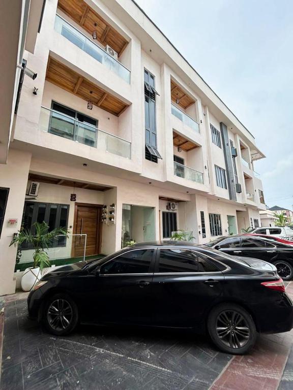 a black car parked in front of a building at Olive apartment in Maiyegun