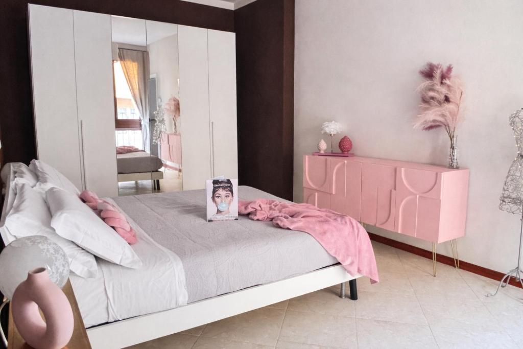 a bedroom with a pink bed and a mirror at Casa di Silvia city center in Verona