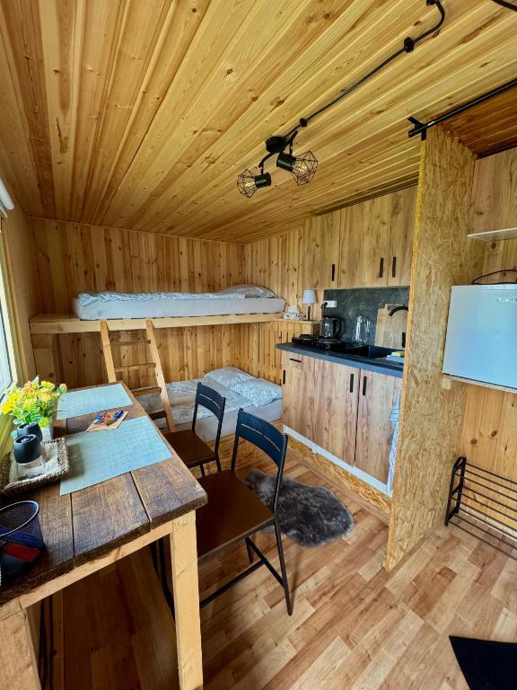 a log cabin with a dining table and a kitchen at Tiny House by the river in Litoměřice