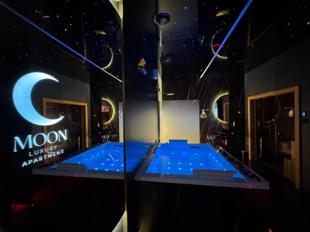 a large blue tub in a room with a sign at Moon Luxury Apartment - Jacuzzi & Sauna in Wałbrzych