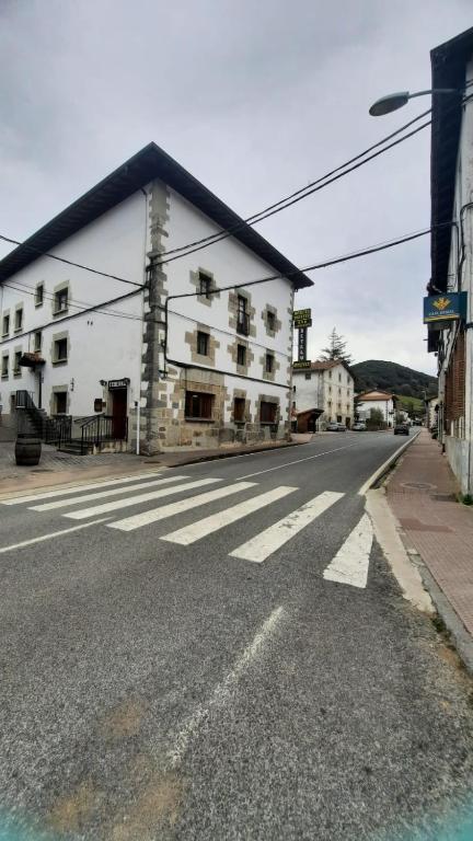 an empty street with a building and a crosswalk at Hostal Betelu in Betelu