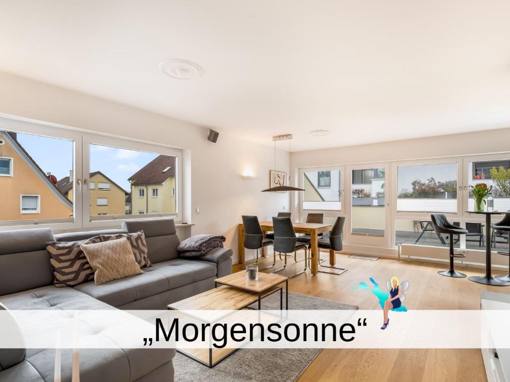 a living room with a couch and a table at Ferienwohnung Morgensonne - modern und freundlich in zentraler Lage in Langenargen