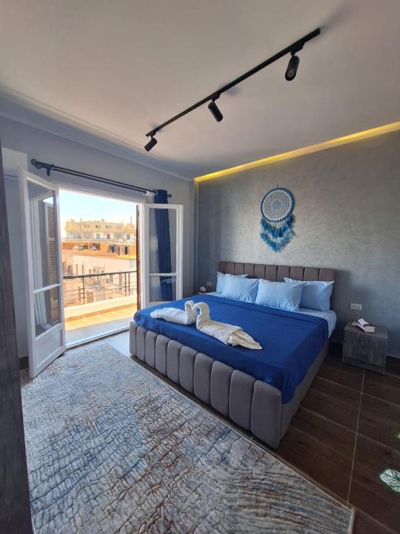 ein Schlafzimmer mit einem großen blauen Bett und einem großen Fenster in der Unterkunft Elite apartment in Kairo