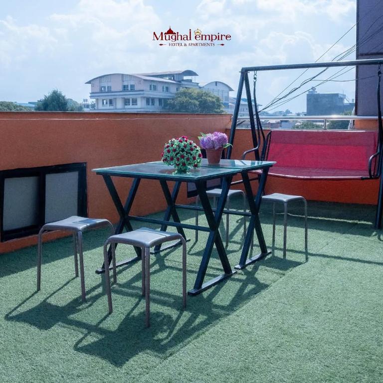 a table and two chairs on a balcony at Mughal Empire Hotel Pvt ltd in Pātan