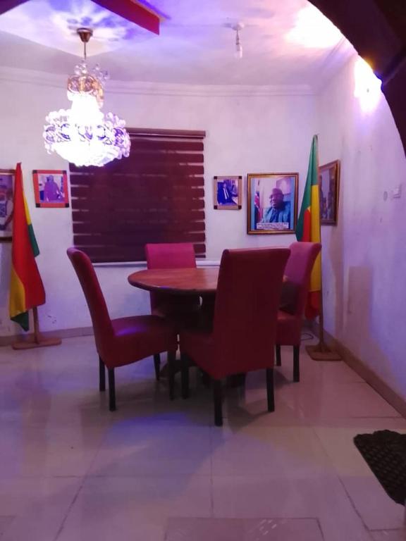 a dining room with a table and chairs and a chandelier at July 16th hotel and event centre in Alagbado
