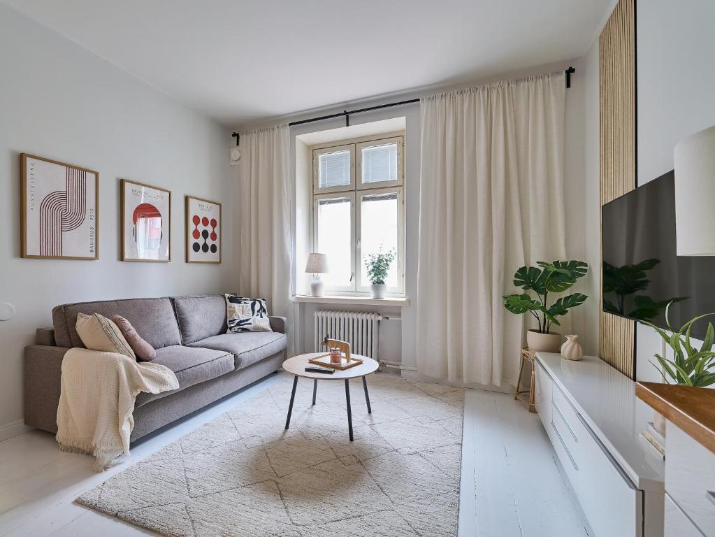 a living room with a couch and a table at Beautiful and Spacious Studio in Helsinki in Helsinki