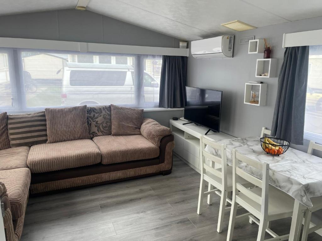 a living room with a couch and a table at Alberta holiday park in Whitstable