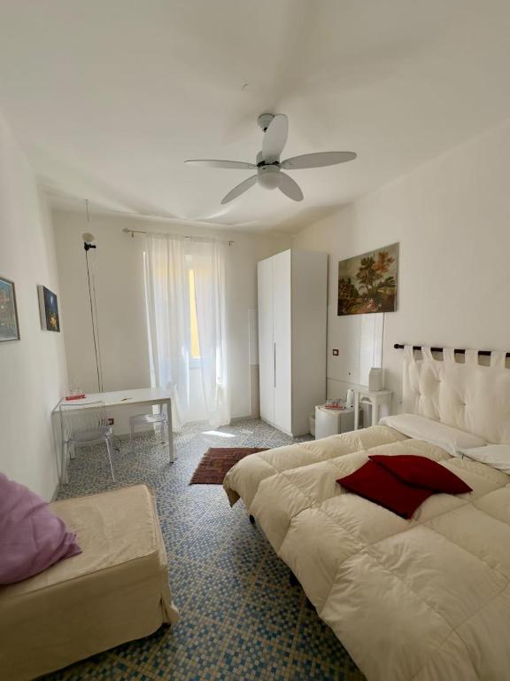 a bedroom with two beds and a ceiling fan at Affittacamere Giulia in Vernazza