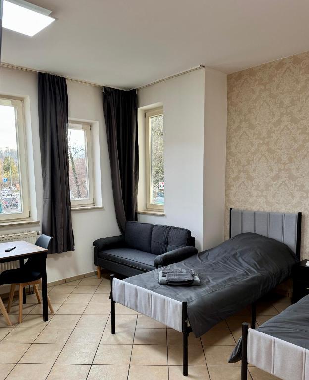 a bedroom with a bed and a couch and a table at Apartment-Herrlingen in Blaustein