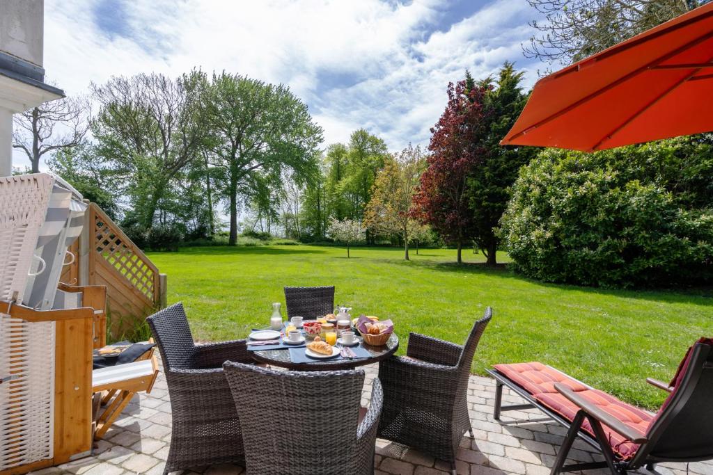 a patio with a table and chairs and an umbrella at Ferienwohnung Fehmarn in Fehmarn