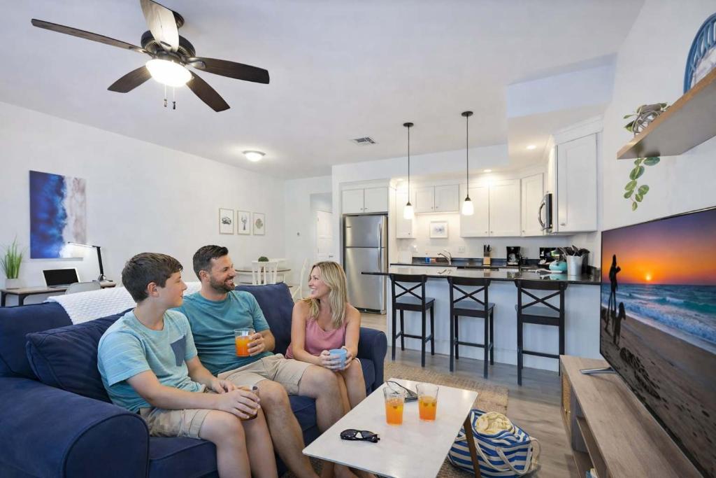 a group of people sitting on a couch in a living room at Steps to Beach King Bed Hampton Beach Hideaway in Hampton