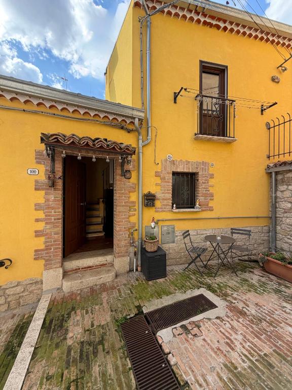 a yellow building with a door and a balcony at Dimora San Mercurio 100 in Campobasso