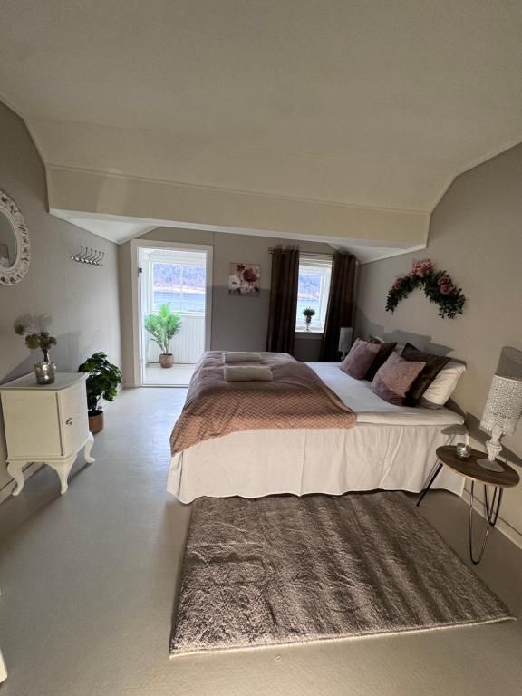 a large bedroom with a large bed and a rug at Villa Utsikten Kirketaket in Åndalsnes