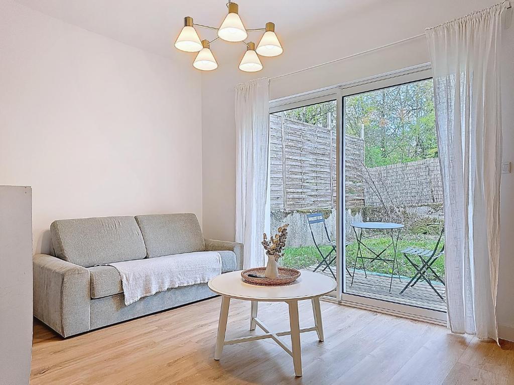 a living room with a couch and a table at Appartement Le Porto in Cholet