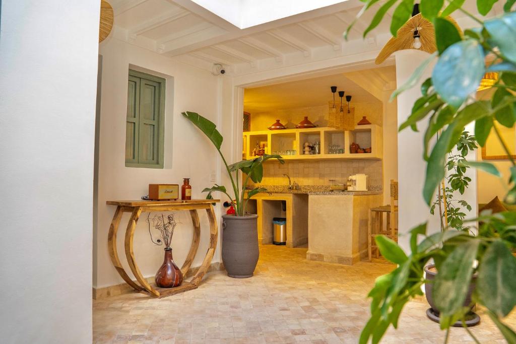 a living room with a table with a plant at Riad Yamat privatisé au cœur de la Médina 3 chambres 10 min Jemaa el-Fna in Marrakesh