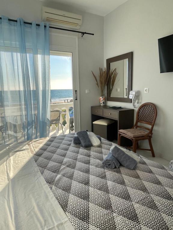 a bedroom with a bed with a view of the ocean at Thalassa apartments in Marathias