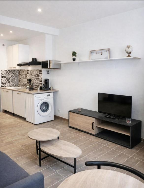 a living room with a table and a kitchen at Le Cocon du Ventoux Studio cosy à Carpentras in Carpentras