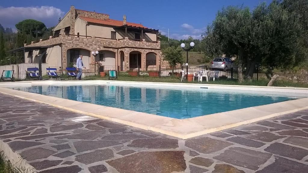 a swimming pool in front of a house at Le Querce in Campiglia Marittima