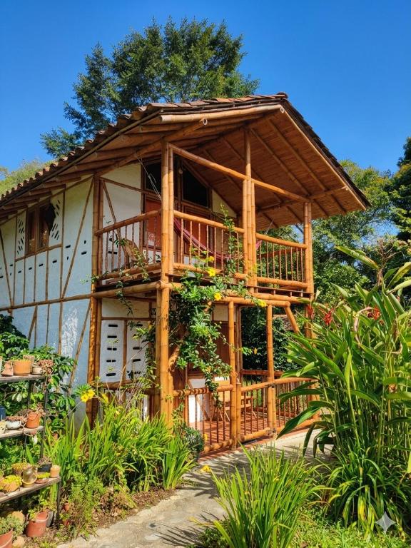 a wooden house with a balcony and plants at Cabaña Ecológica Finca Cometa in San Agustín