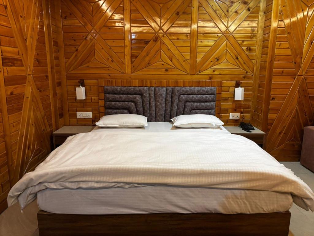 a bedroom with a large bed with wooden walls at JB Hotel and Resort in Lohaghāt