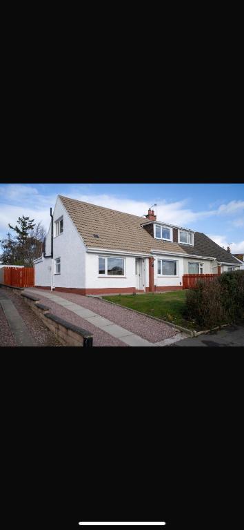 a large white house with a brown roof at Royal Apartment in Inverness