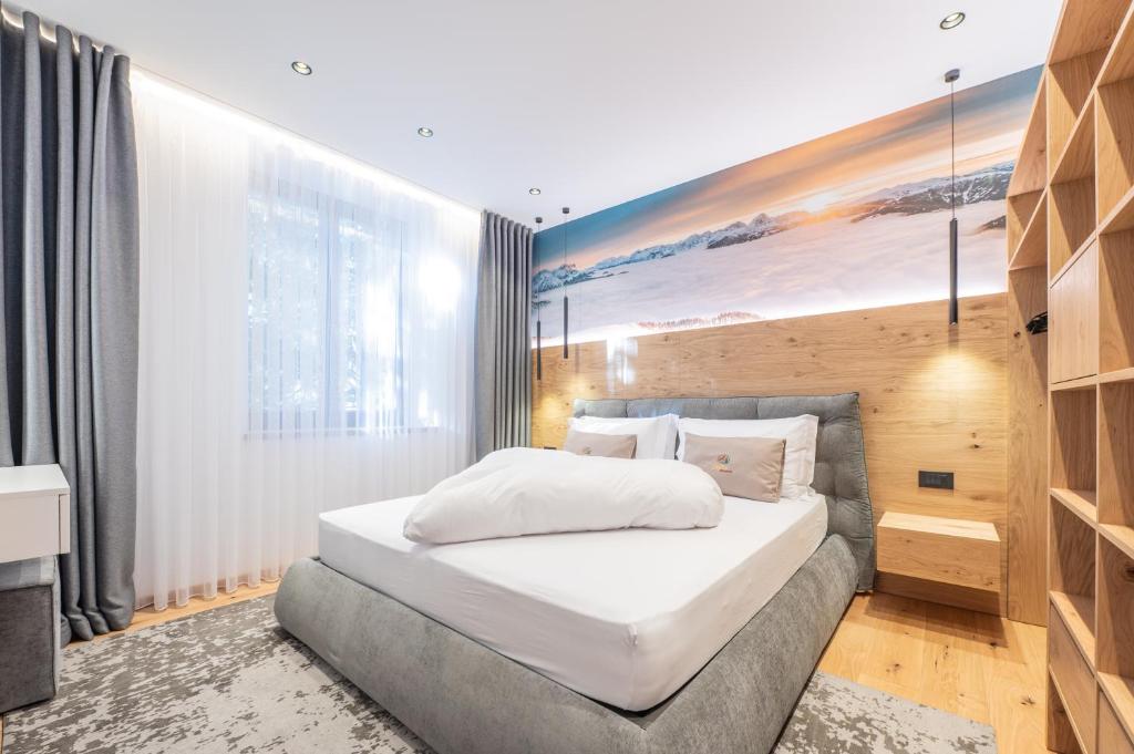 a bedroom with a bed and a painting on the wall at Plan de Corones Apartment in San Sigismondo