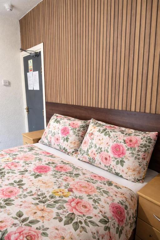 a bedroom with a bed with floral pillows at blackpool central lodge And Rooms in Blackpool