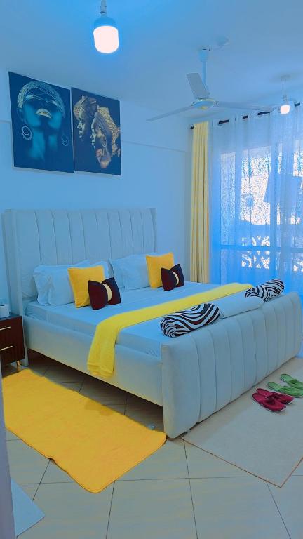 a large bed with pillows on it in a room at Staycation One and Two Bedroom apartment Mombasa in Mombasa