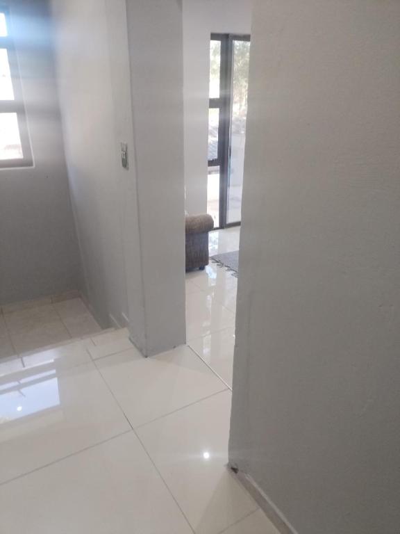 a white room with a door and a white tile floor at Peaceful Nest in St Lucia