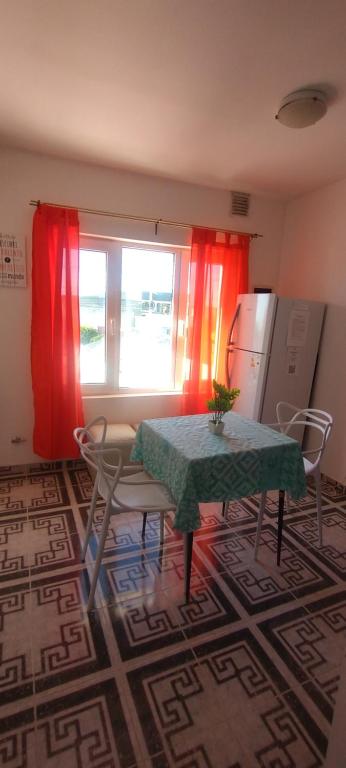 a kitchen with a table and a window with red curtains at Dulce Adelina III - Zona Céntrica in Río Grande