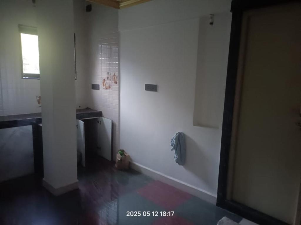 a white room with a toilet and a window at Sada Niwas in Ucassaim