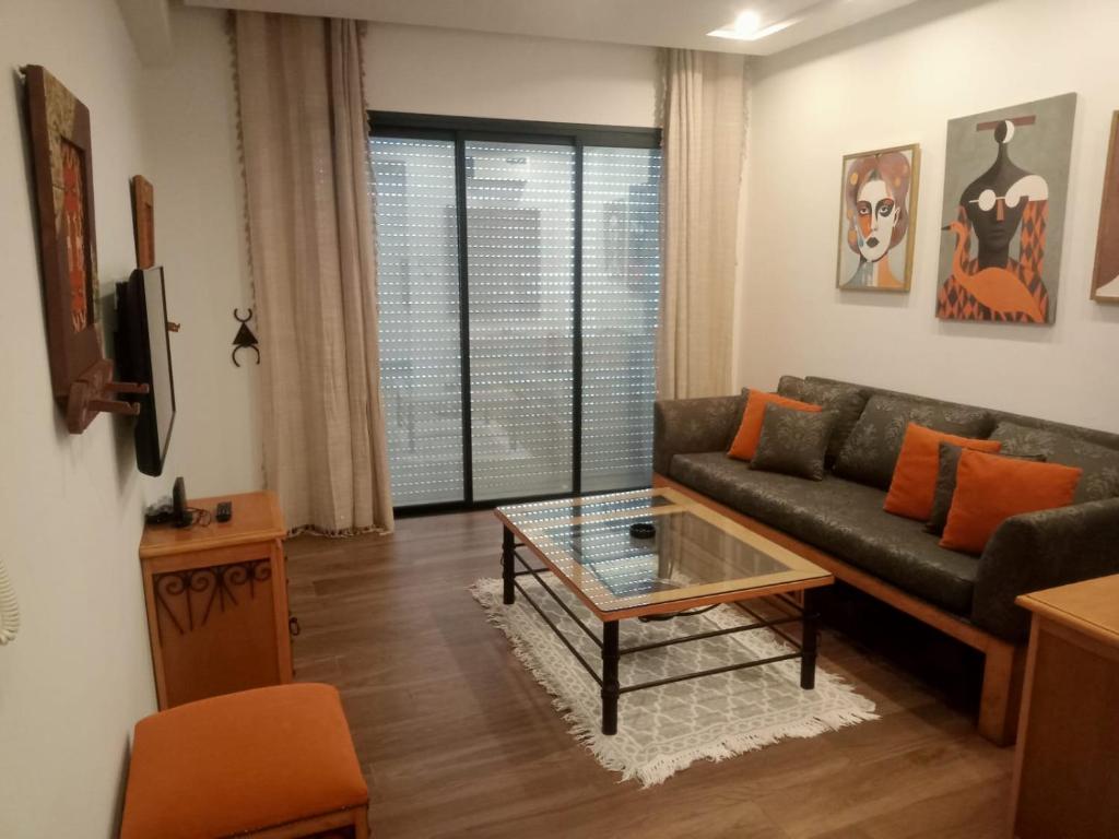a living room with a couch and a table at Esmeralda in Douar el Hafey
