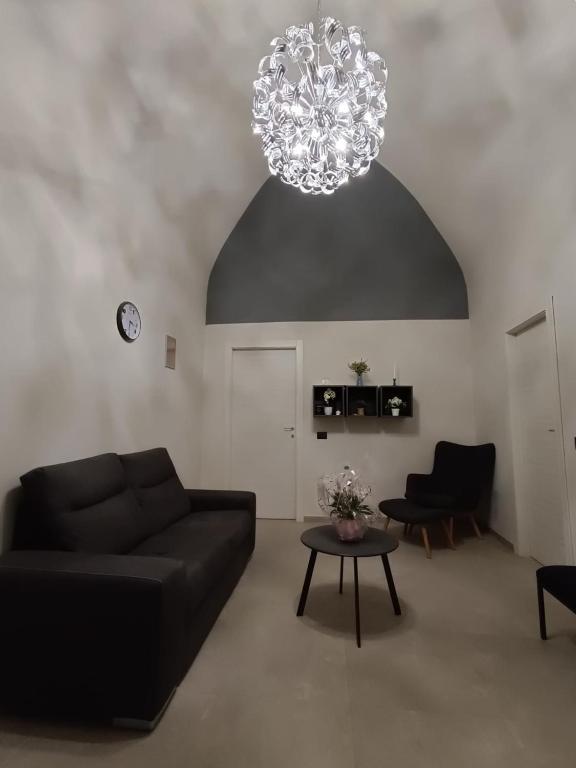 a living room with a black couch and a chandelier at Casa Muce in Novi Ligure