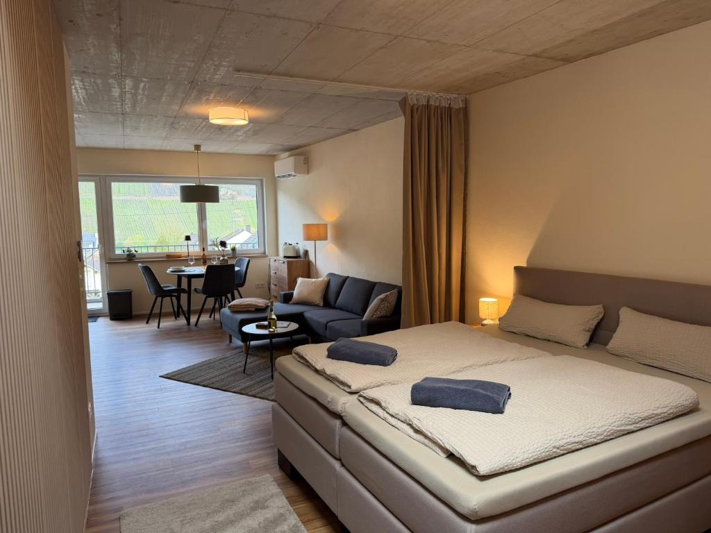 a bedroom with a bed and a living room at Sonnenufer Apartment & Wein III in Bernkastel-Kues