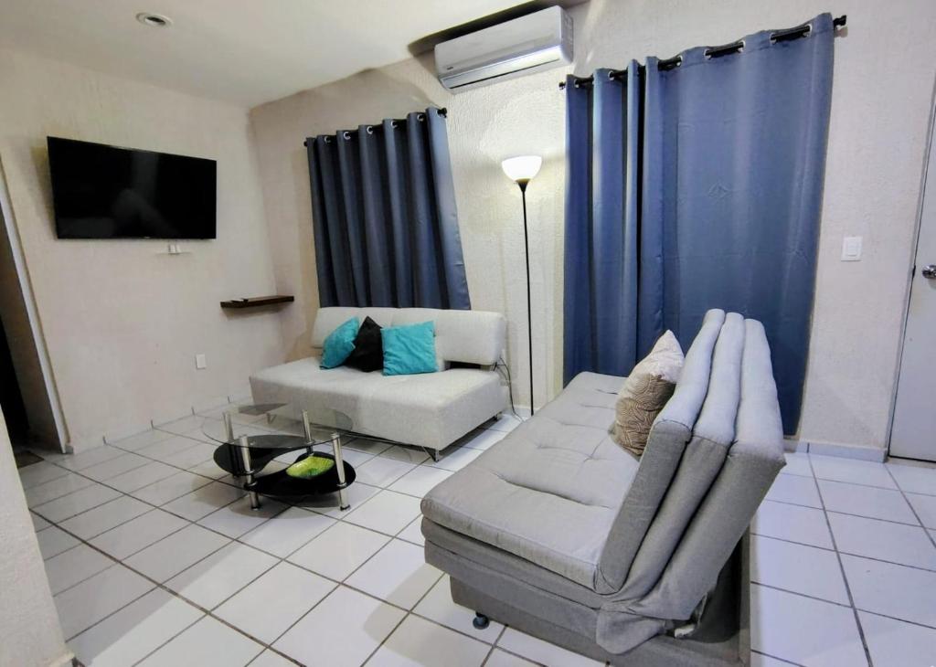 a living room with a couch and a chair at Casa Jaguar 7 in Puerto Morelos