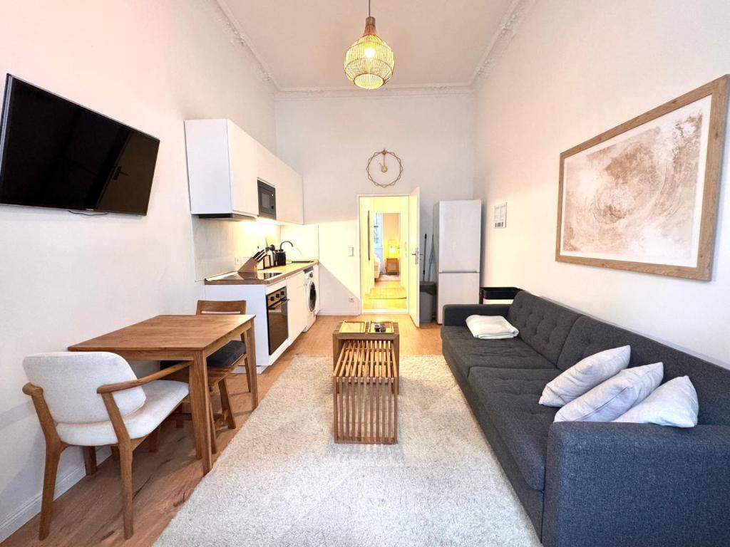a living room with a couch and a table and a kitchen at Best Spot in XBerg in Berlin